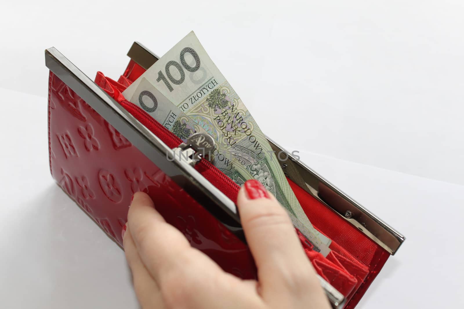 Money sticking out of a wallet on white background by Kasia_Lawrynowicz