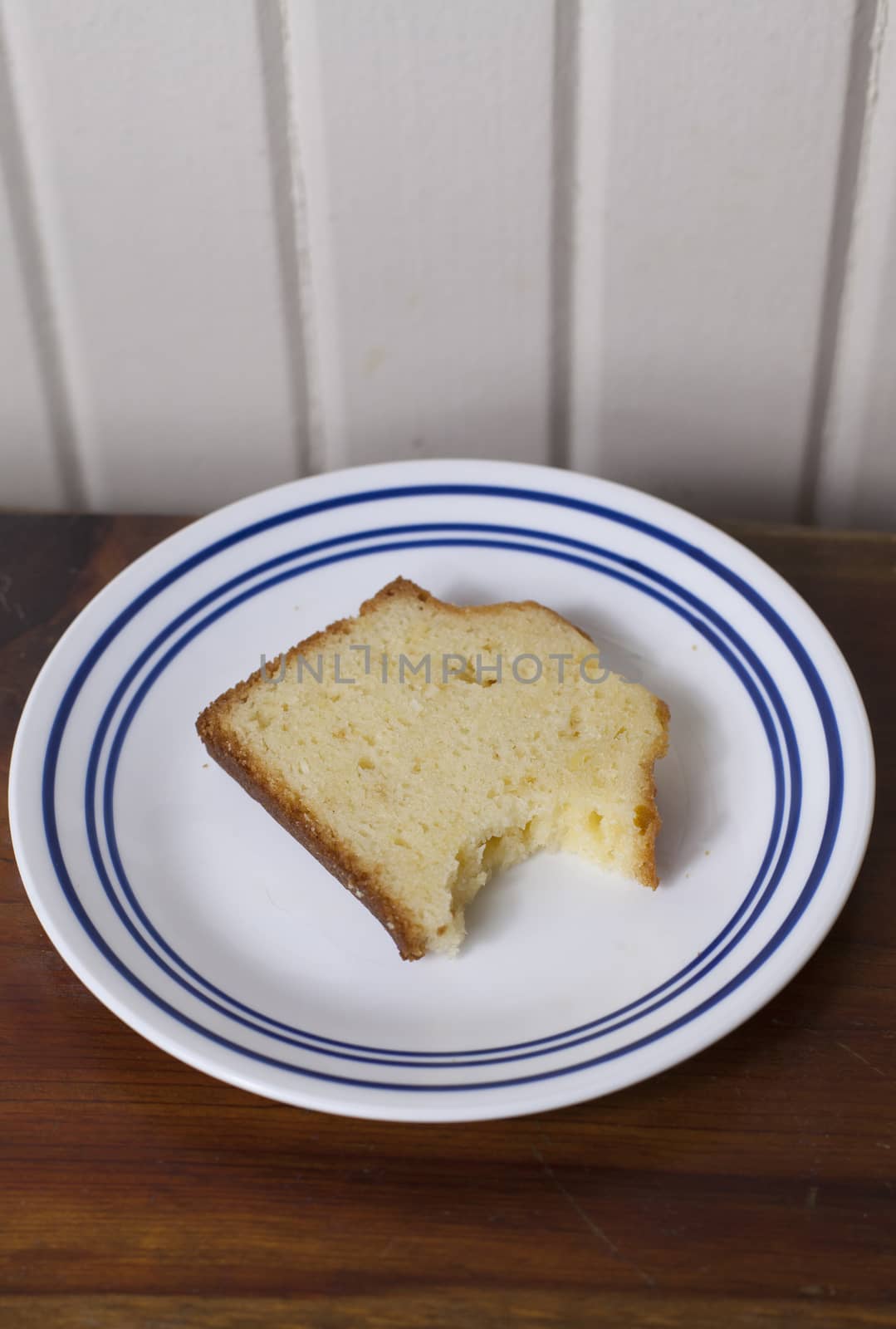 A single slice of pound cake with a bite taken out