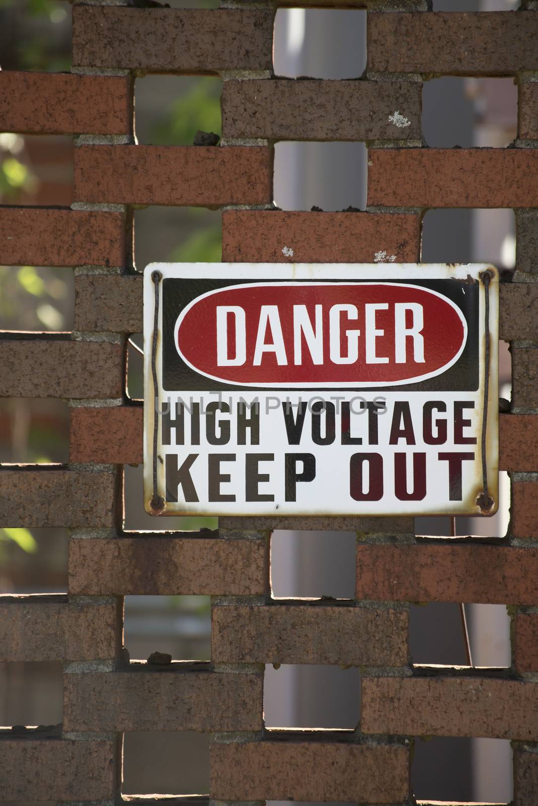 Danger high voltage keep out sign on a red brick wall