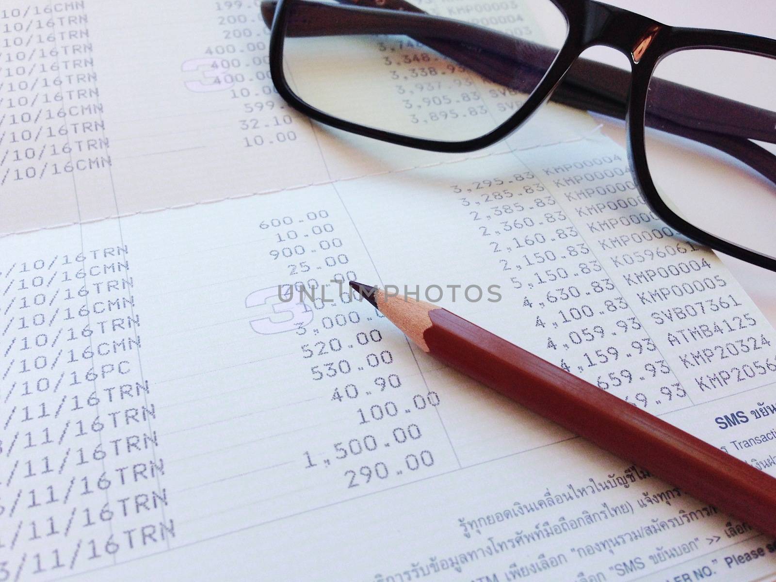 Business, finance, saving money, banking, loan, investment, taxes or accounting concept : Pen and eyeglasses on saving account book or financial statement