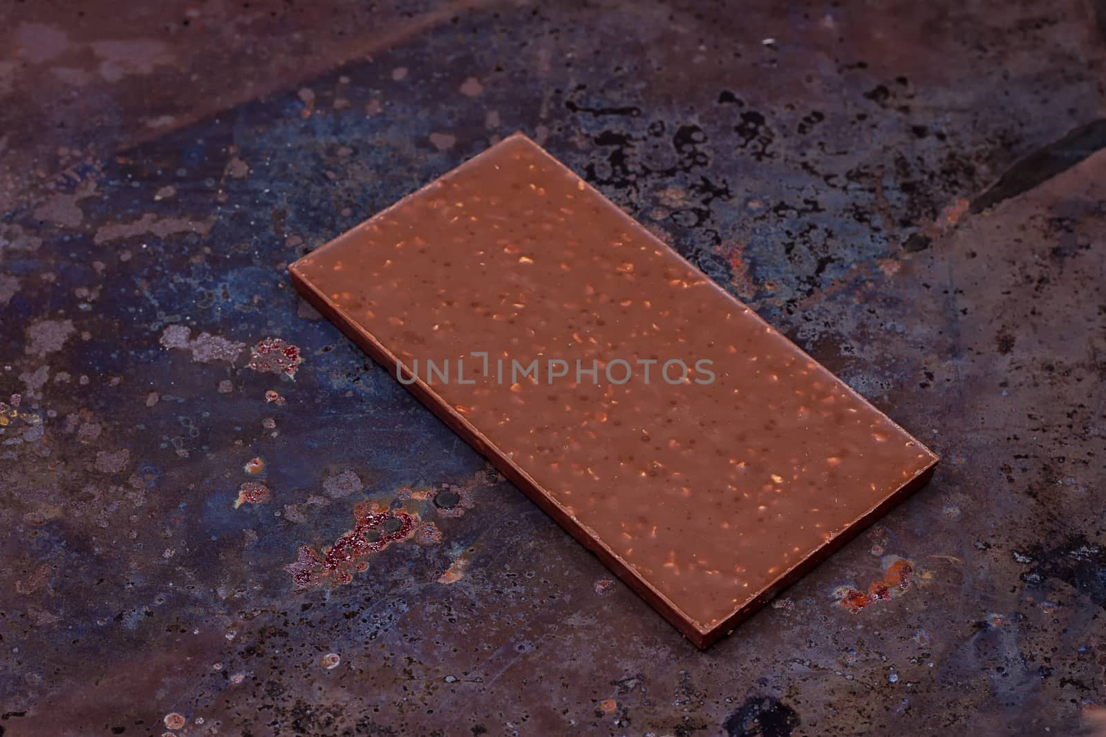 Milk chocolate bar on a black grunge background