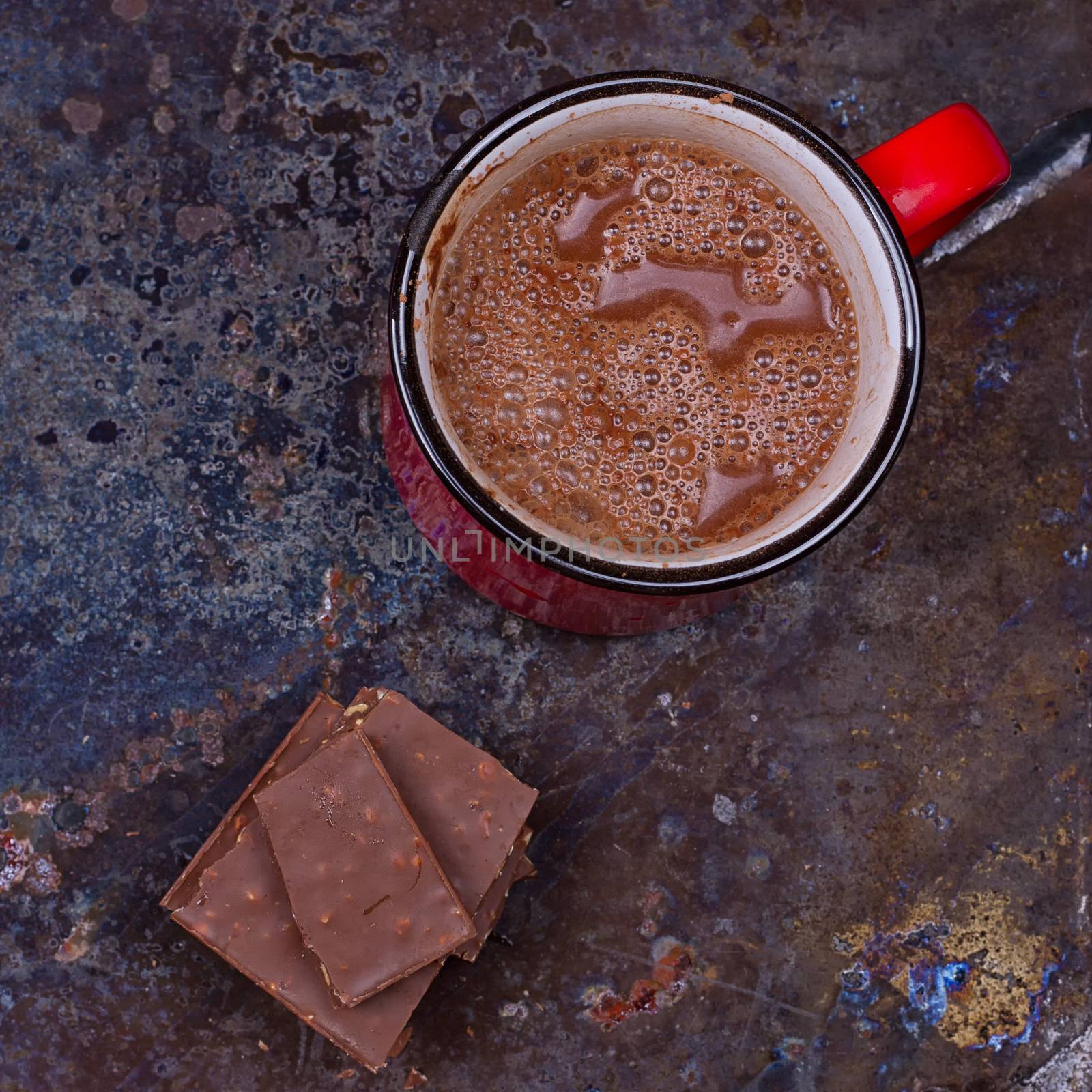 Hot chocolate in mug with chocolate on grunge dark table