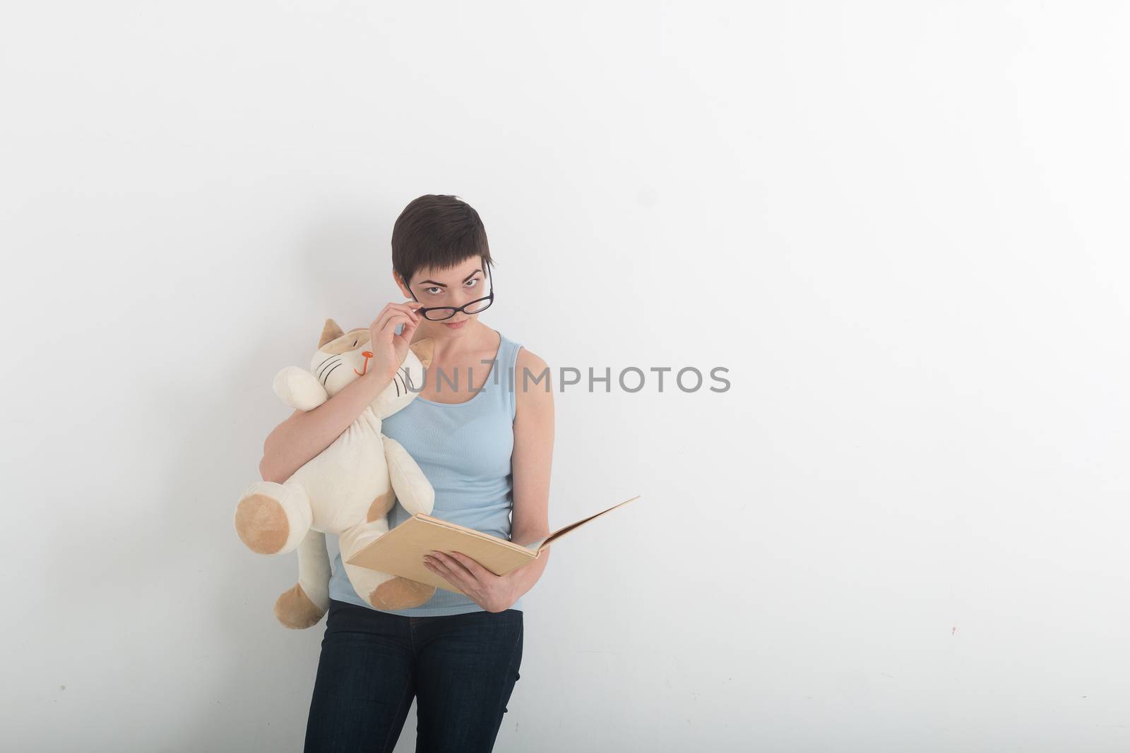 Pretty brunette woman reading book with her plush toy cat