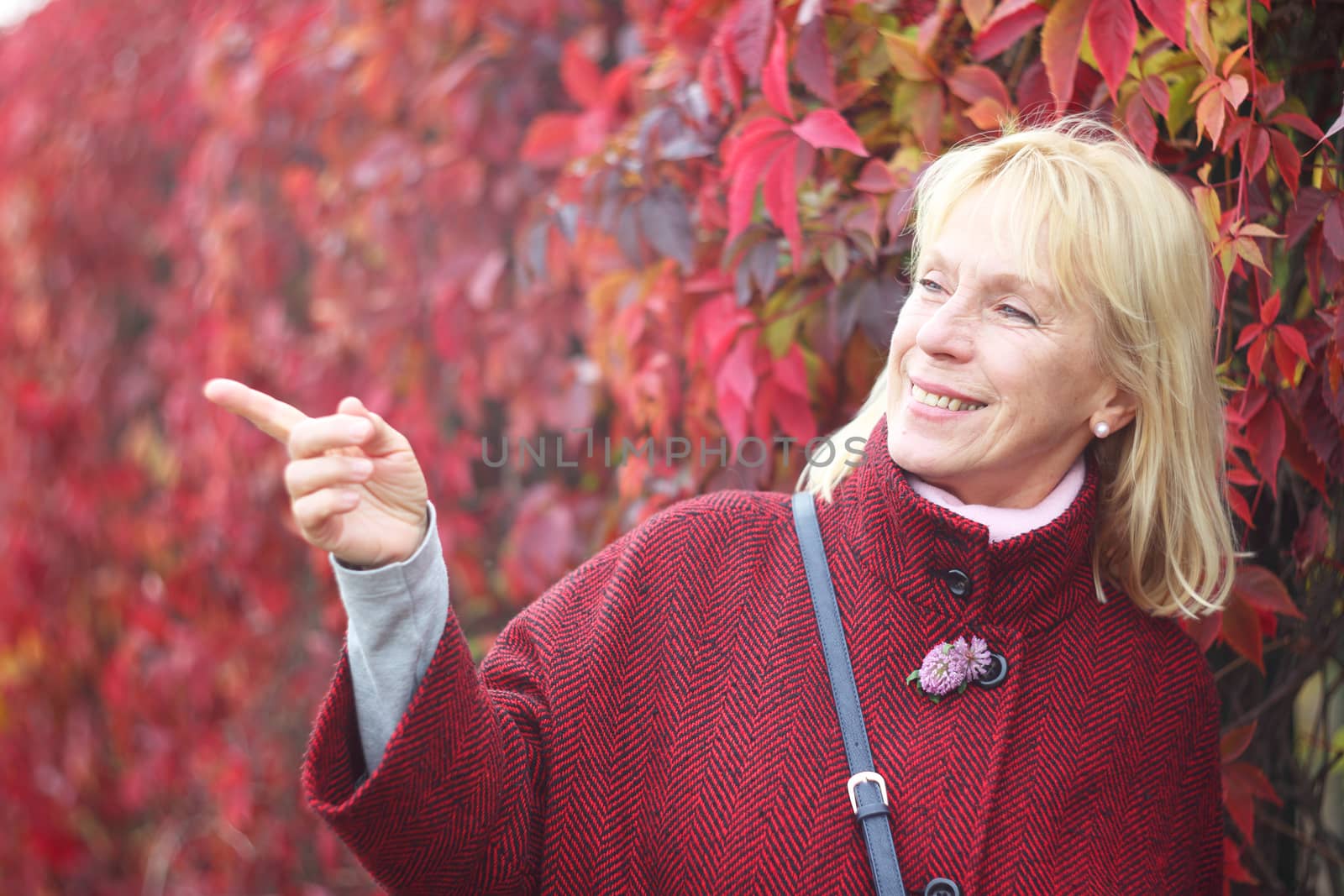 Senior woman in autumn park by destillat