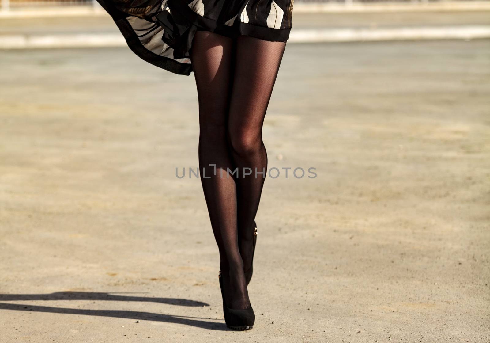 Woman's legs in black pantyhose, outdoor by Nobilior