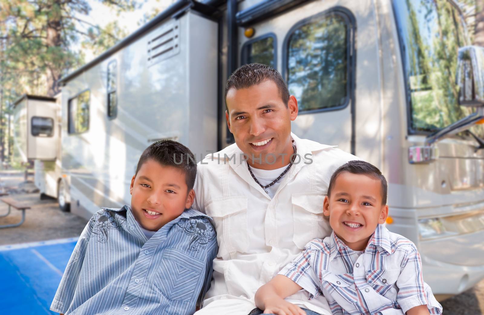 Happy Hispanic Father and Sons In Front of Their Beautiful RV At The Campground. by Feverpitched