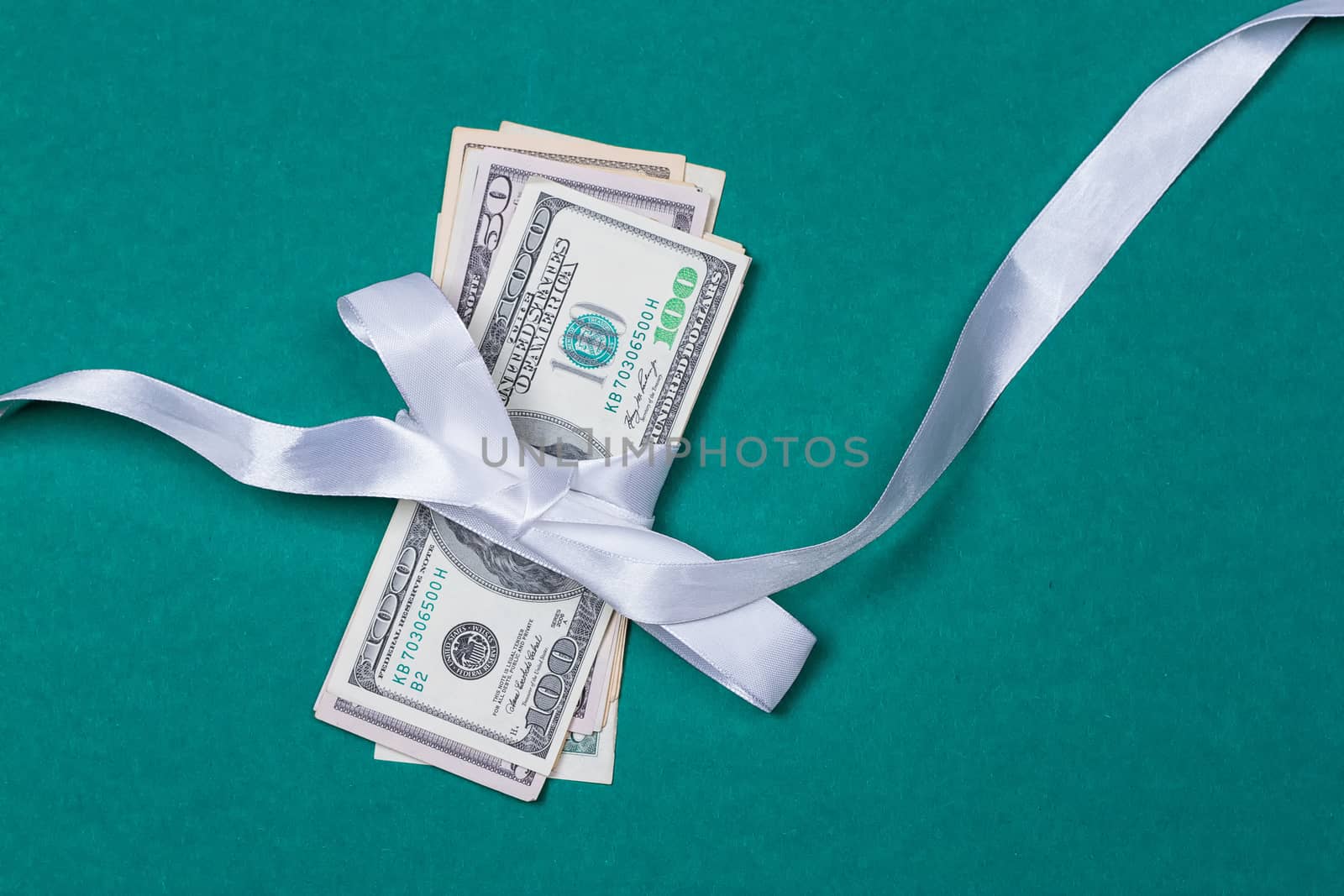dollars in gift wrapping gift concept. on a green background