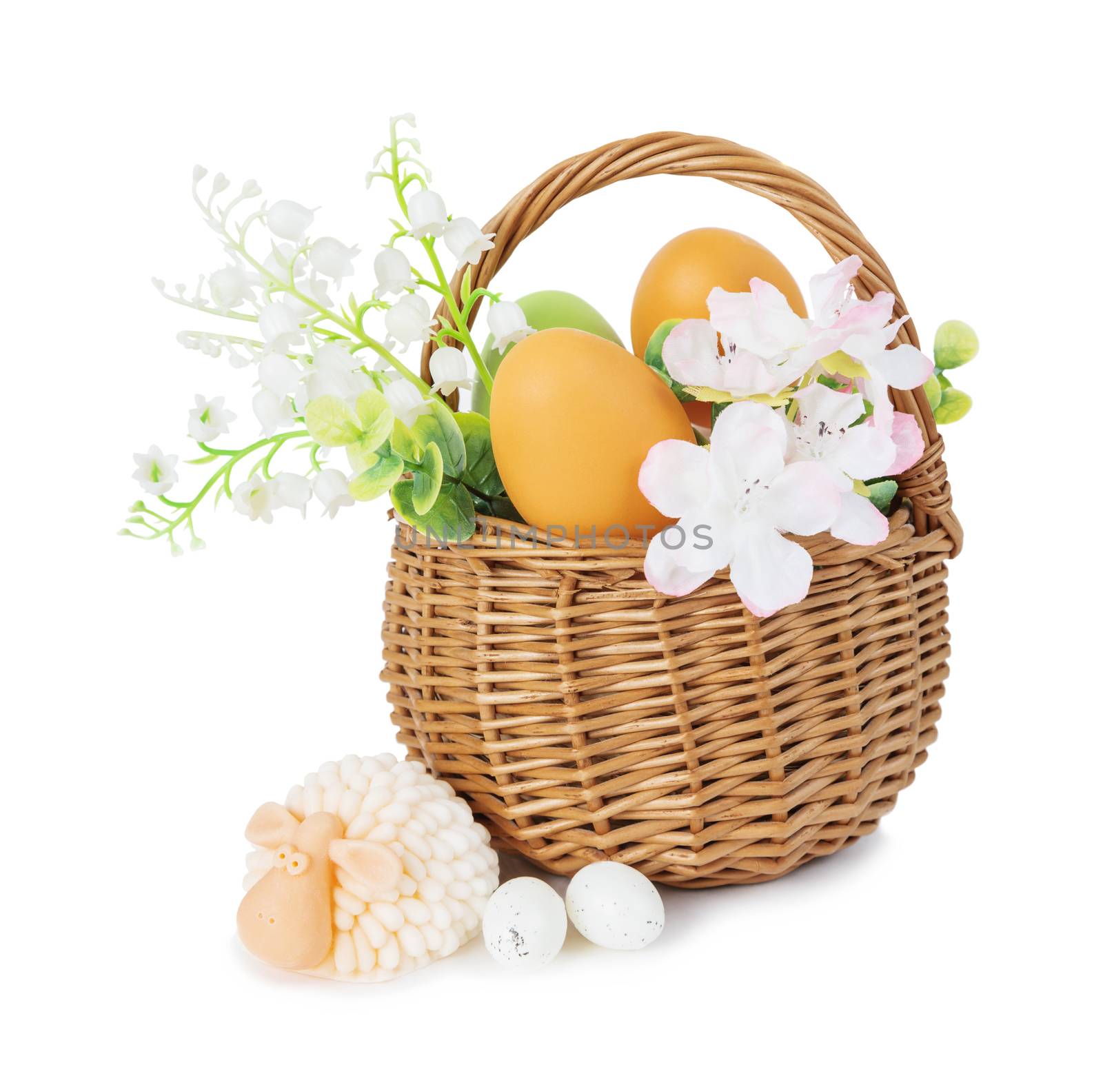 Wicker basket with orange Easter and lilies of the valley and other flowers as well as little lamb isolated on white background