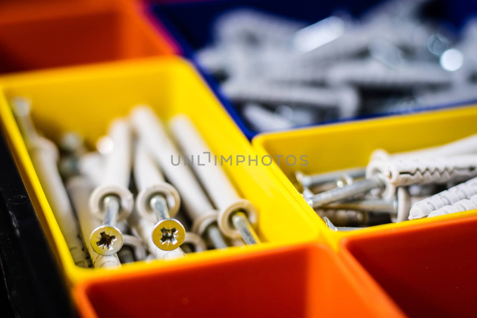 Screws segregated in plastic colored containers. Box for builder by wytrazek