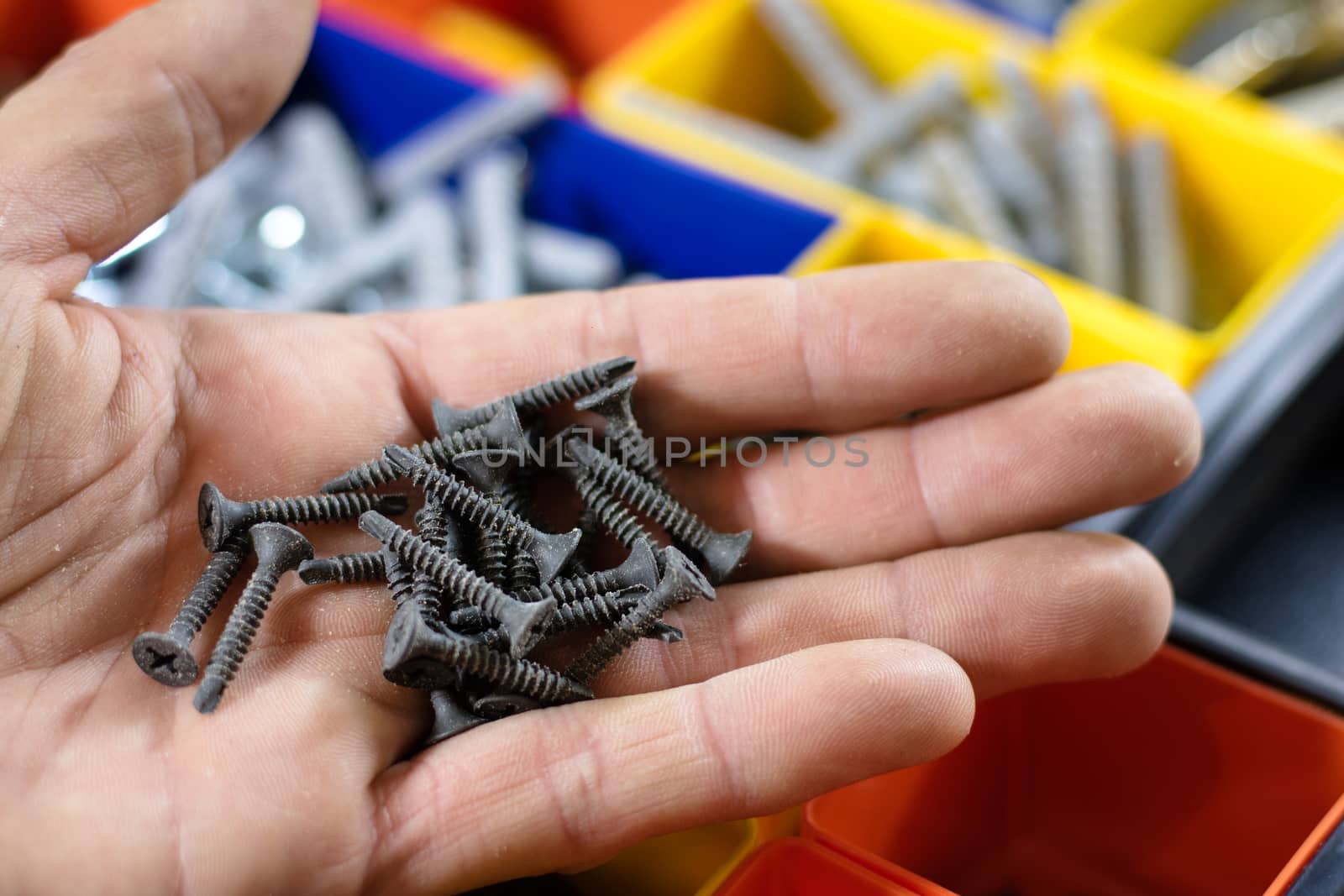 screws on the palm, background sealed screws in colored pots, black background