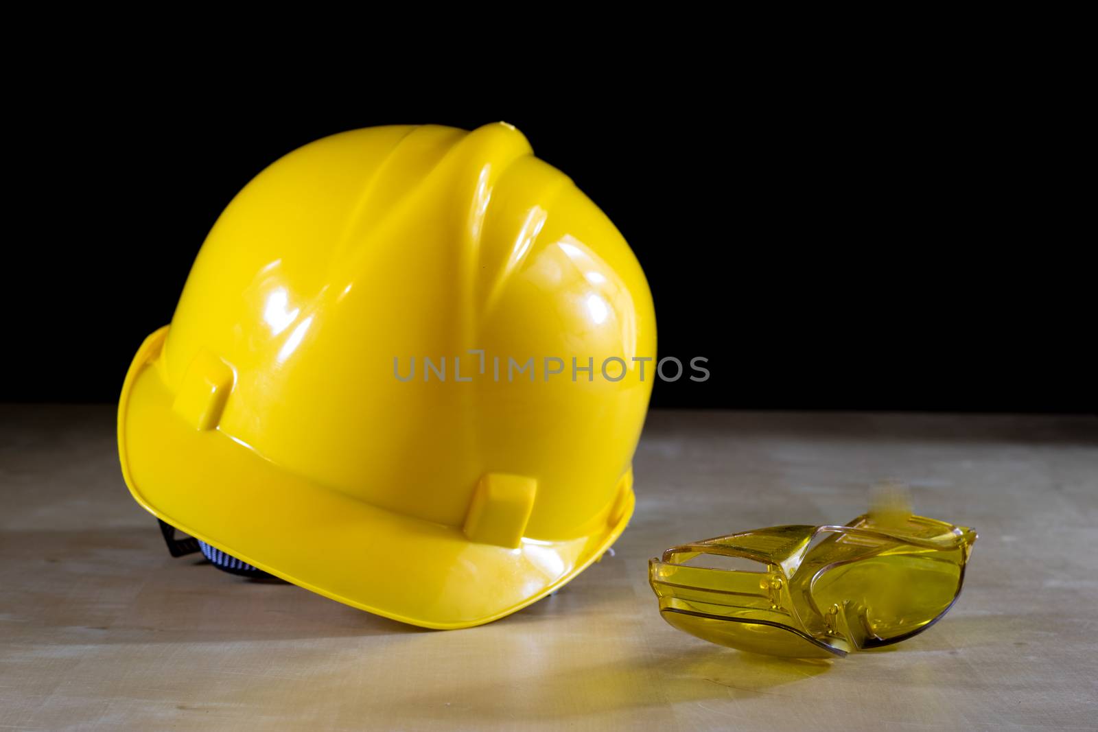 Yellow helmet, safety goggles and work gloves for the worker on  by wytrazek