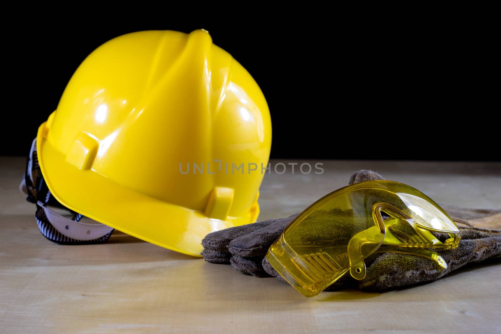 Yellow helmet, safety goggles and work gloves for the worker on  by wytrazek