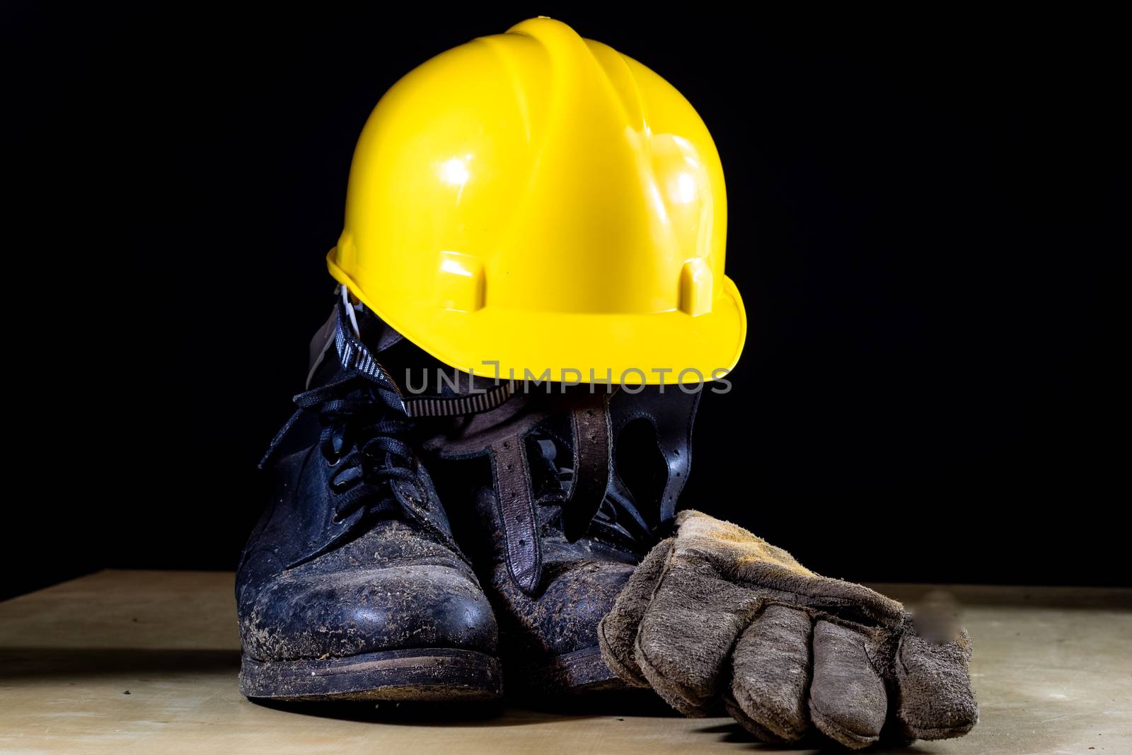 Muddy working boots with helmet and gloves. Accessories for the  by wytrazek