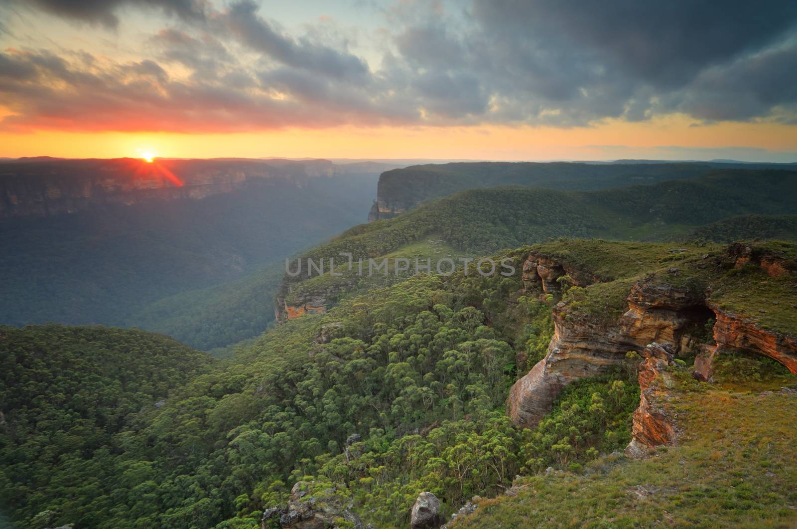 The sun sets in the west over the Grose Valley and  B;ue Mountains from Mt Banks