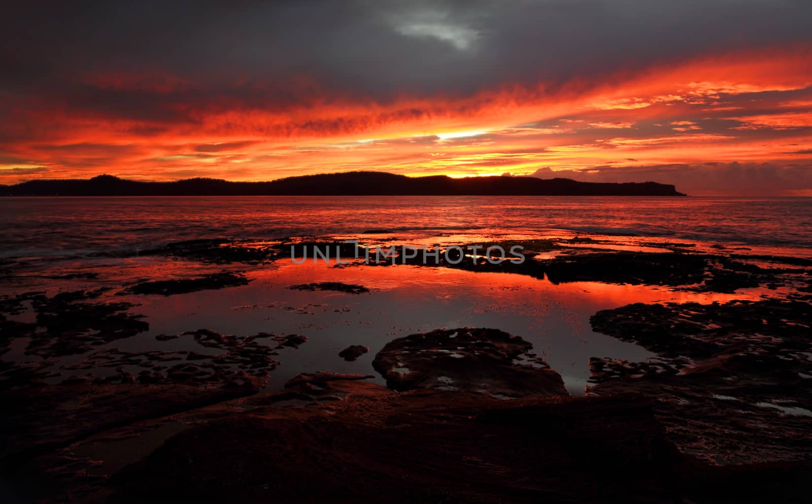 Magnificent red dawn the sky aglow in fiery colours and thus adorns the landscape also.  Location Pearl Beach Australia