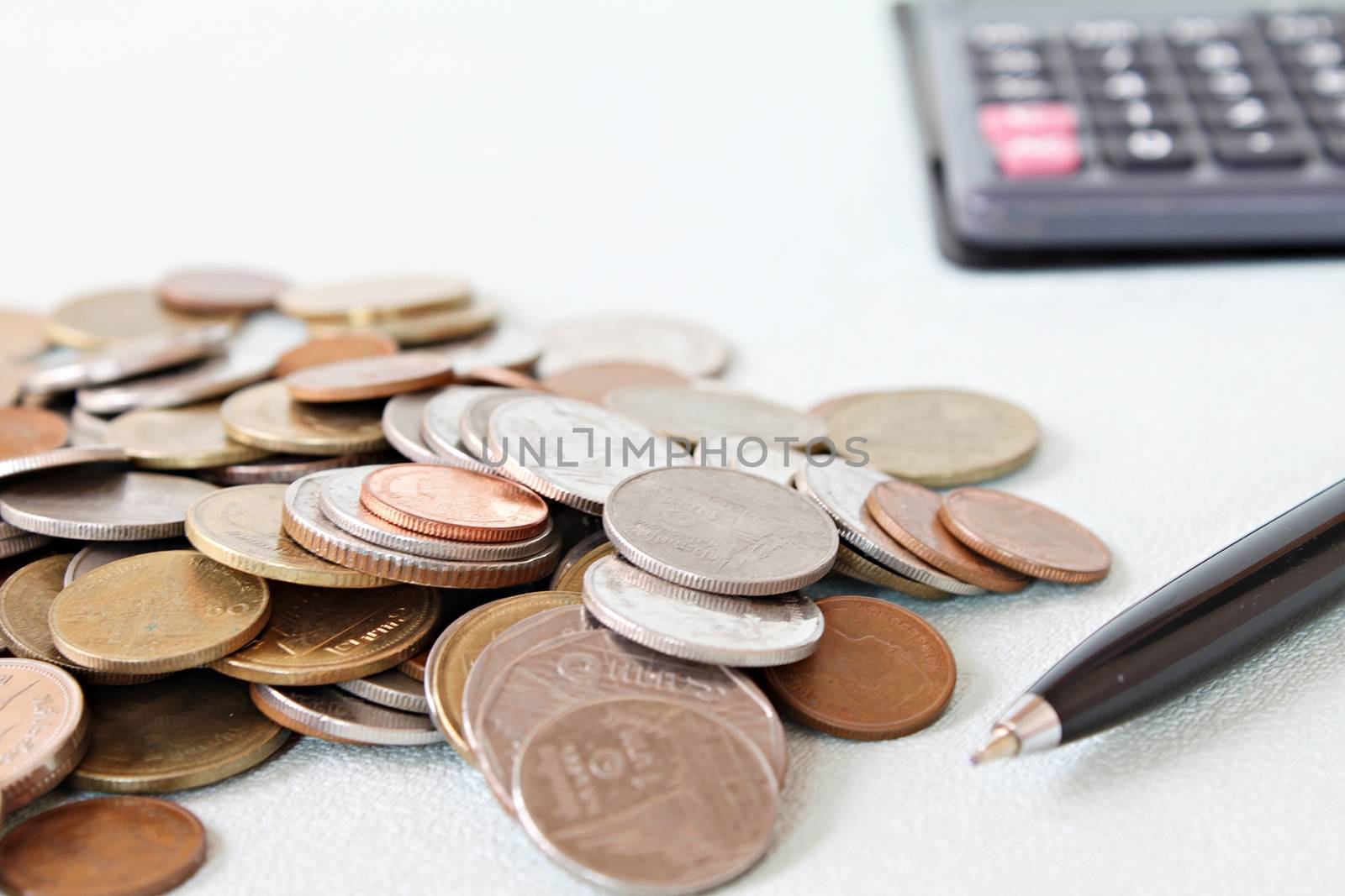 Business, finance, saving money, banking, loan, investment, taxes or accounting concept : Coins, pen and calculator on office desk table