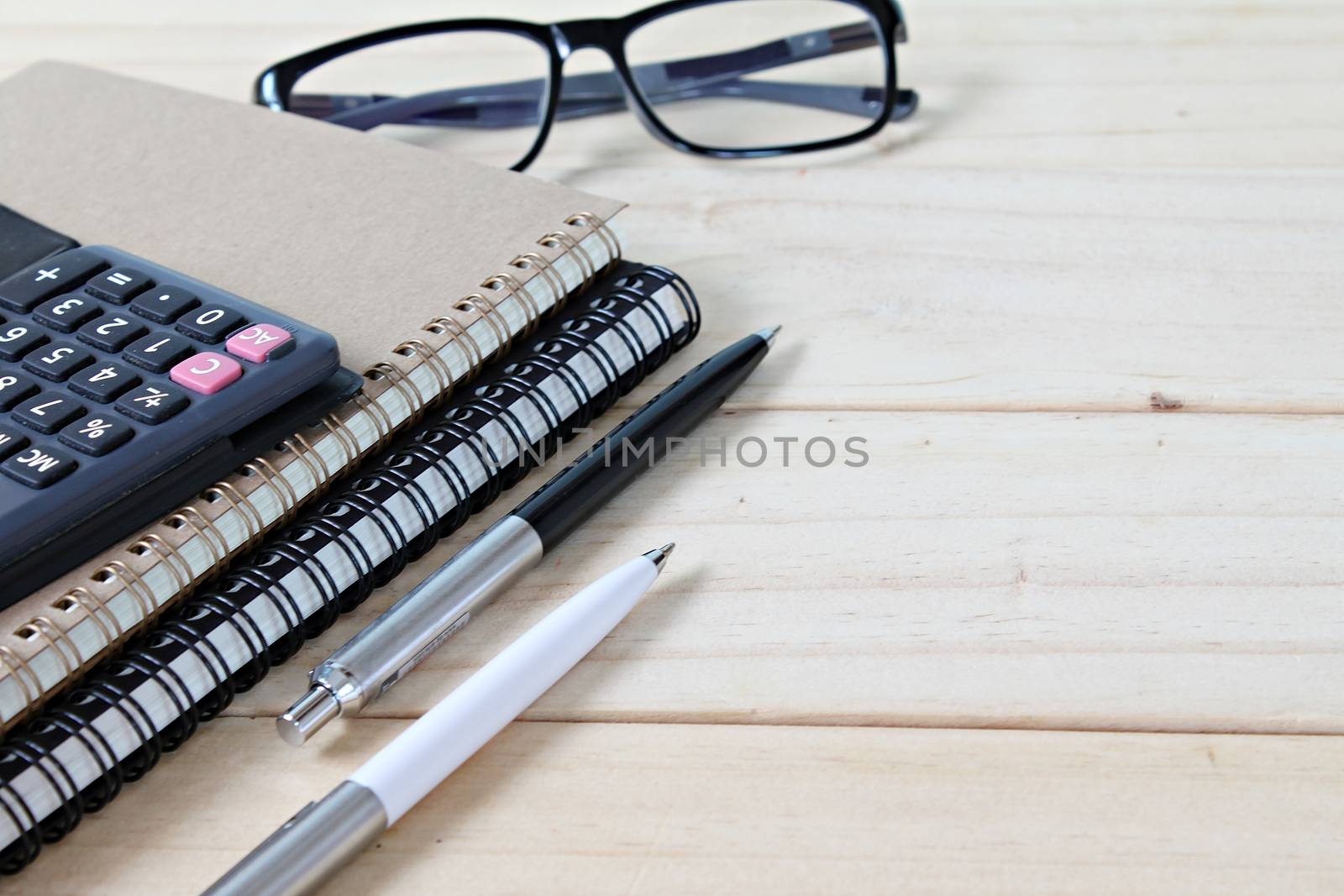 Business, finance, saving money, banking, loan, investment, taxes or accounting concept : Notebooks, calculator and eyeglasses on office desk table