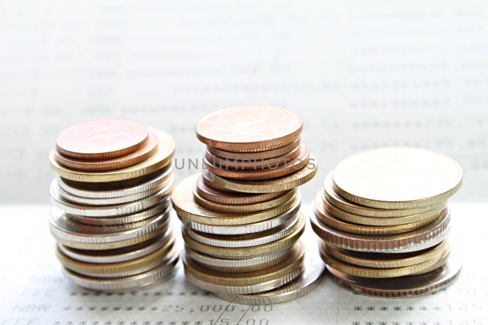 Business, finance, saving money, banking, loan, investment, taxes or accounting concept : Coins stack on saving account book or financial statement
