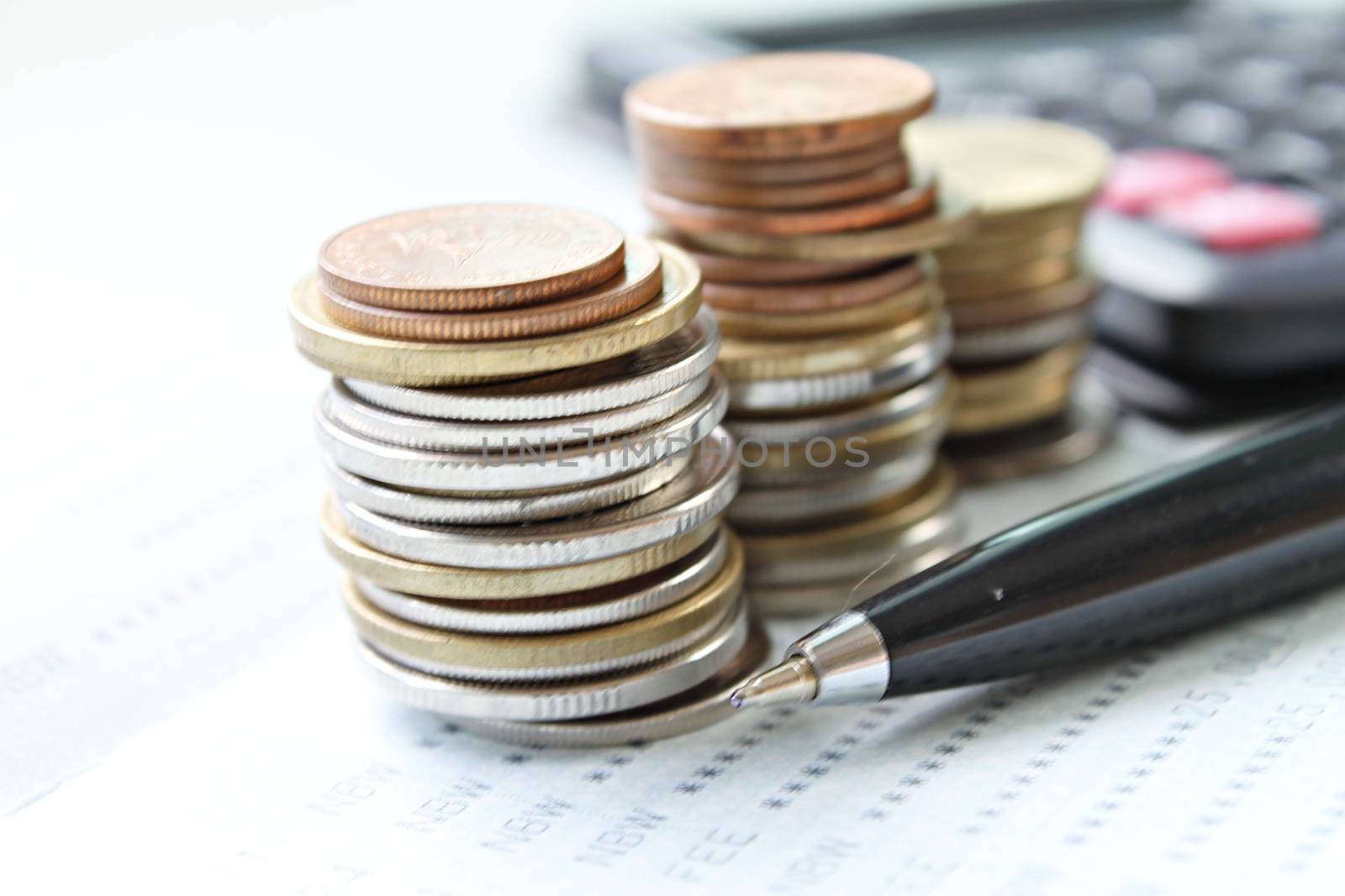 Business, finance, saving money, banking, loan, investment, taxes or accounting concept : Coins stack, pen and calculator on saving account book or financial statement