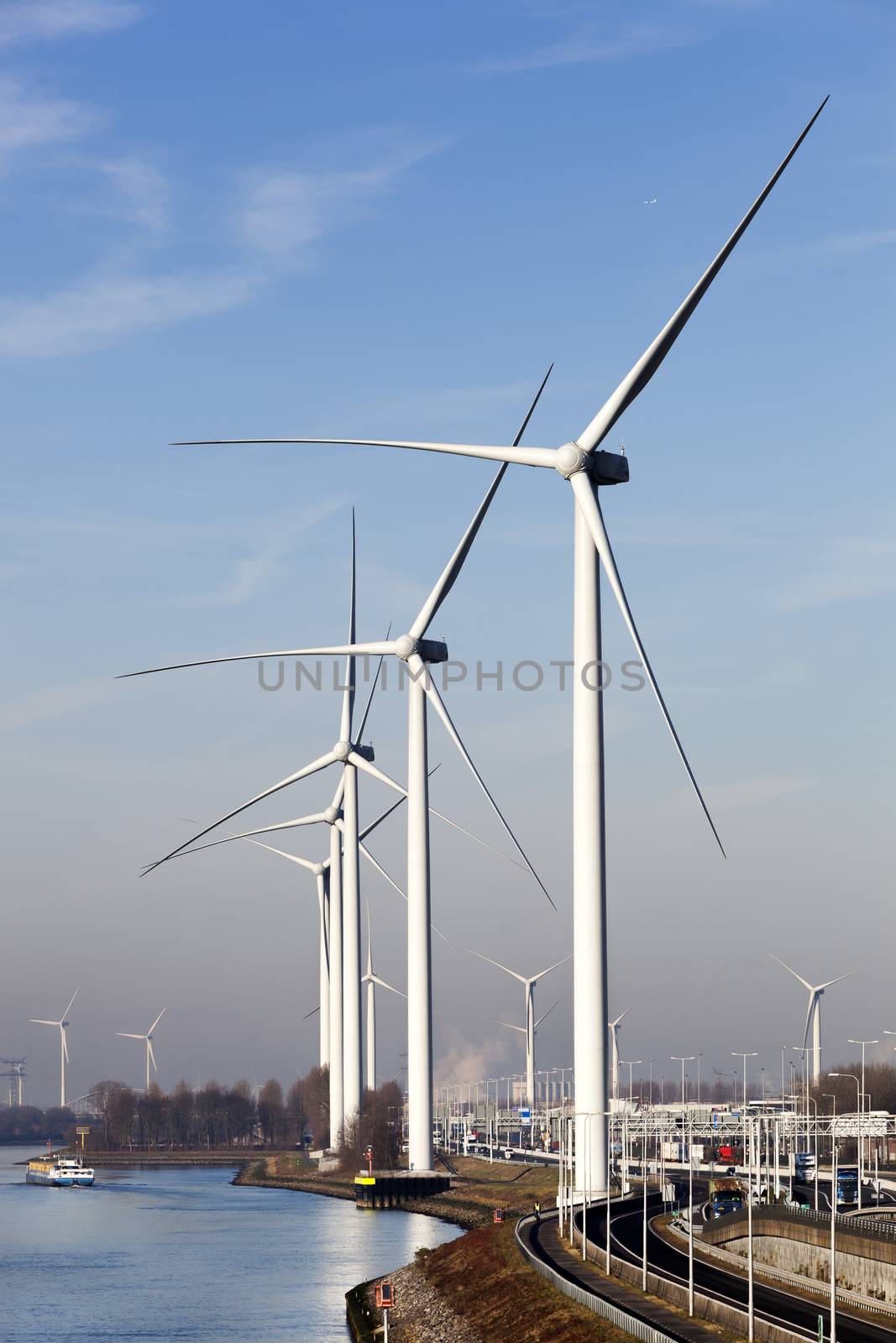 Wind turbines near canal Hartel in industrial area Europoort of Rotterdam in the Netherlands