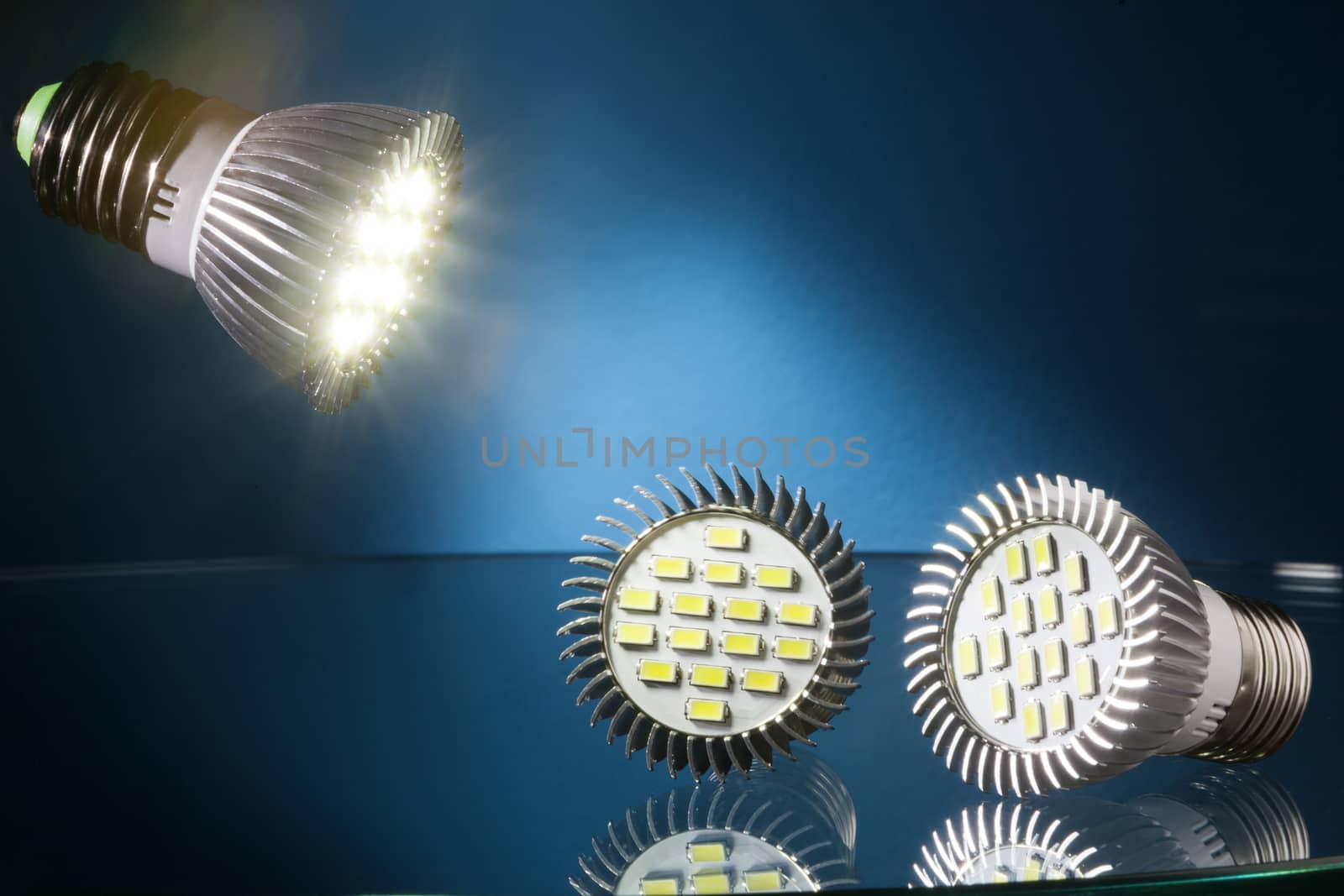 Energy saving  led lights on a glass table and blue background