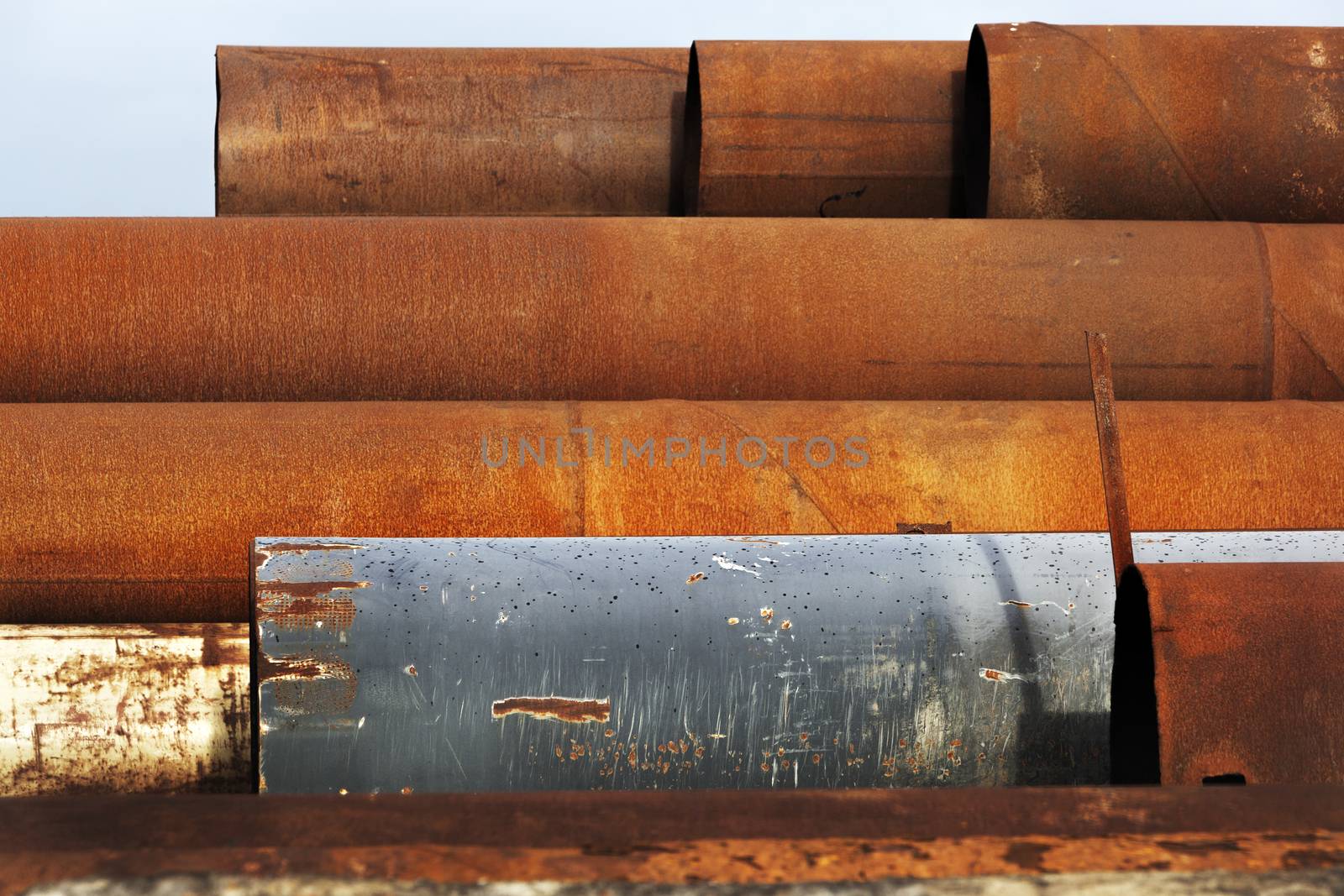 Stack of industrial reusable rusty metal pipes