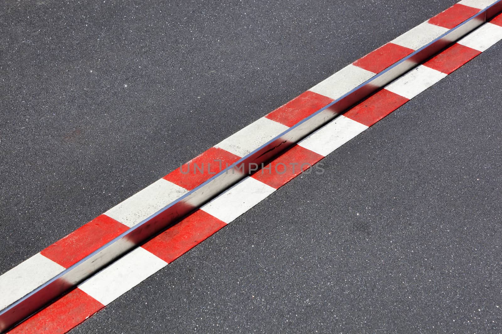 Red and white obstacle warning on asphalt