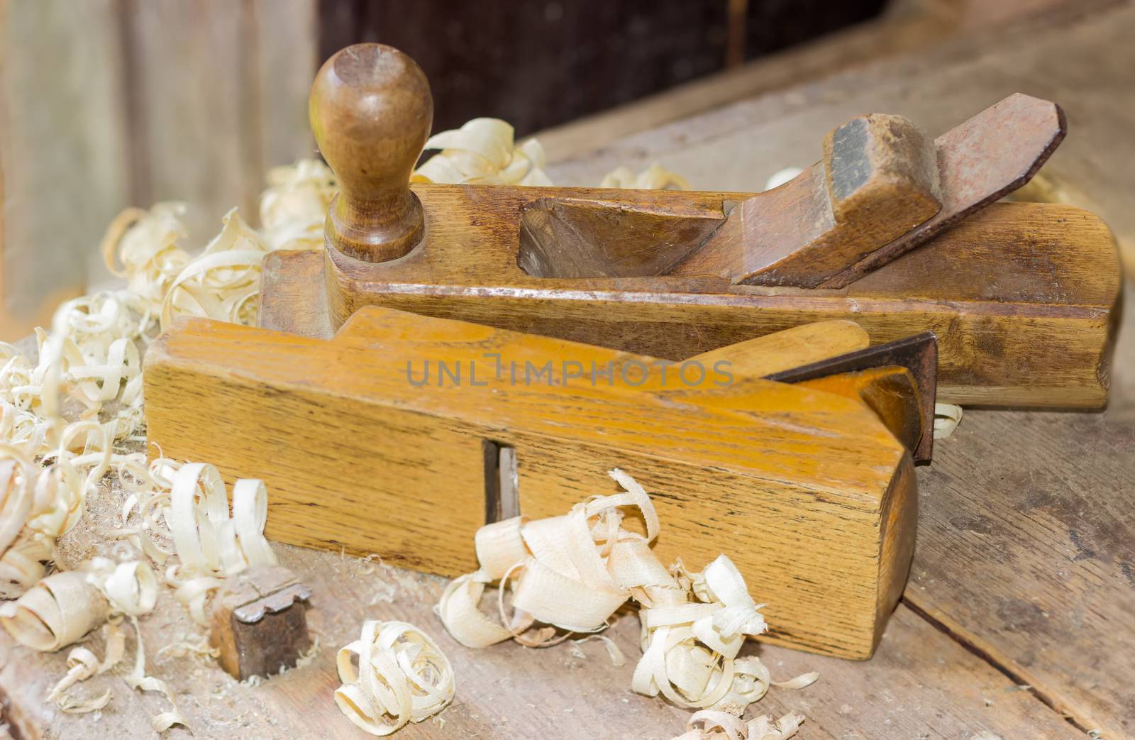 Two old wooden hand planes on old woodworking workbench by anmbph