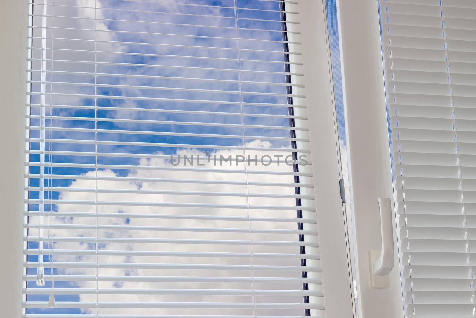 Sky with clouds across Venetian blinds on the window by anmbph