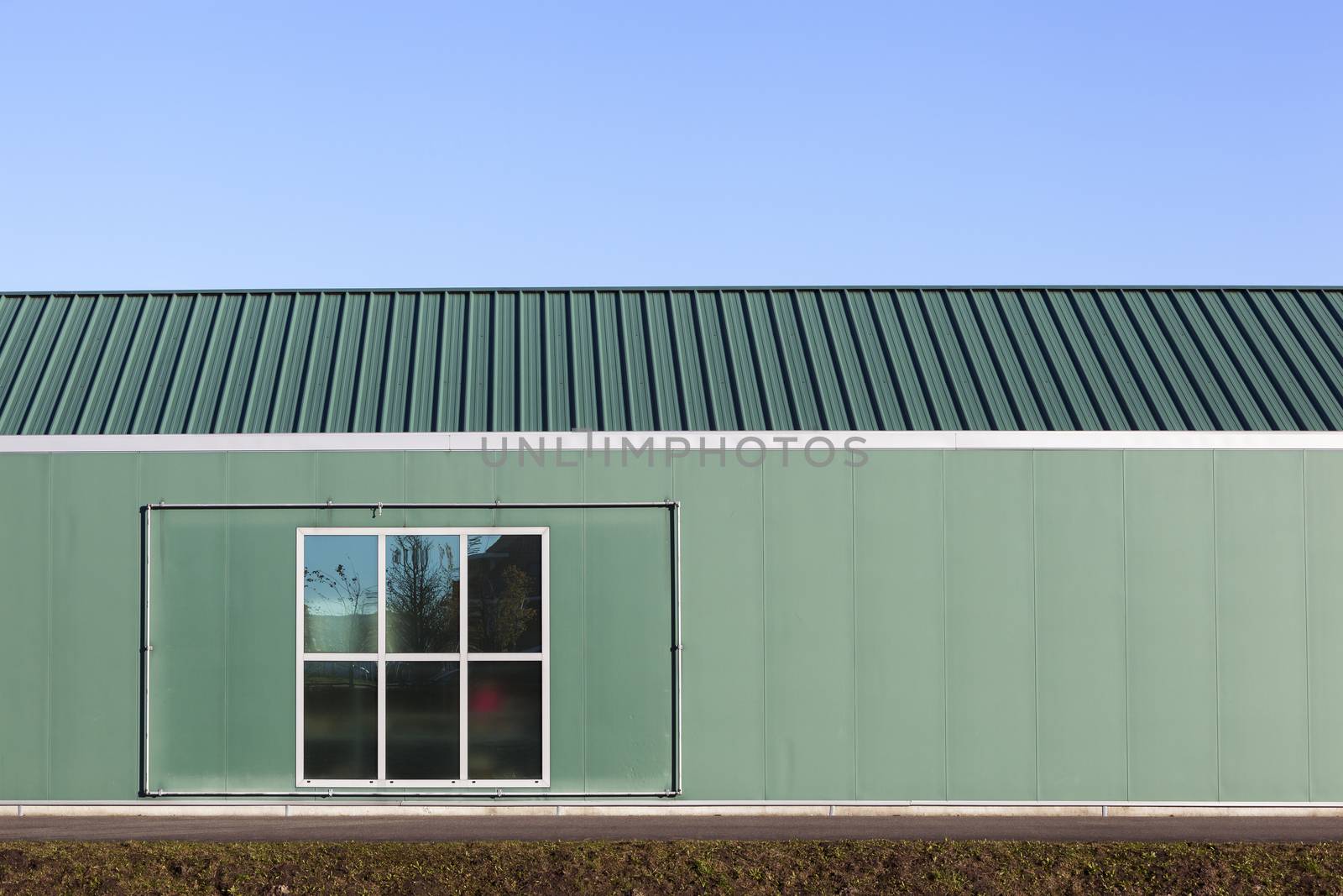 Green industrial building with a metal frame and a window