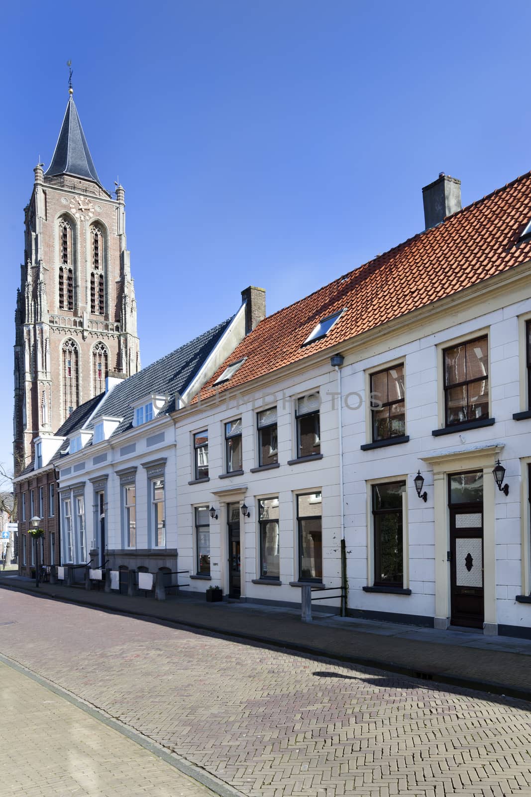 Street with traditional houses and the old church tower in Gorinchem in the Netherlands