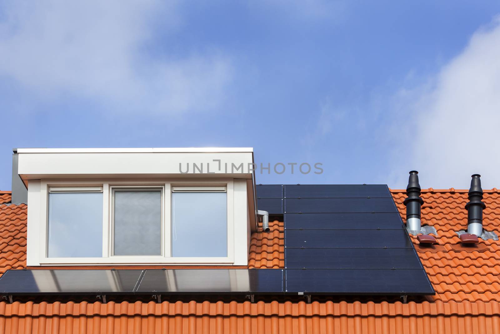 Dormer and solar panels on a red tile roof