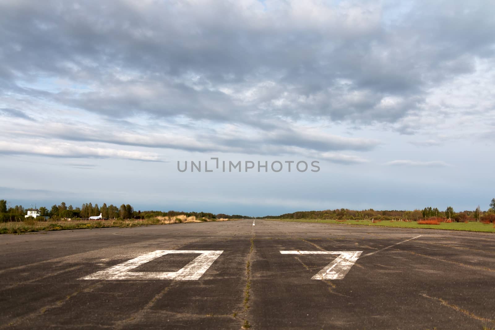 Plane runway, airstrip in the airport terminal with marking on blue sky with clouds to use as background. Travel aviation and holiday concept. Soft focus