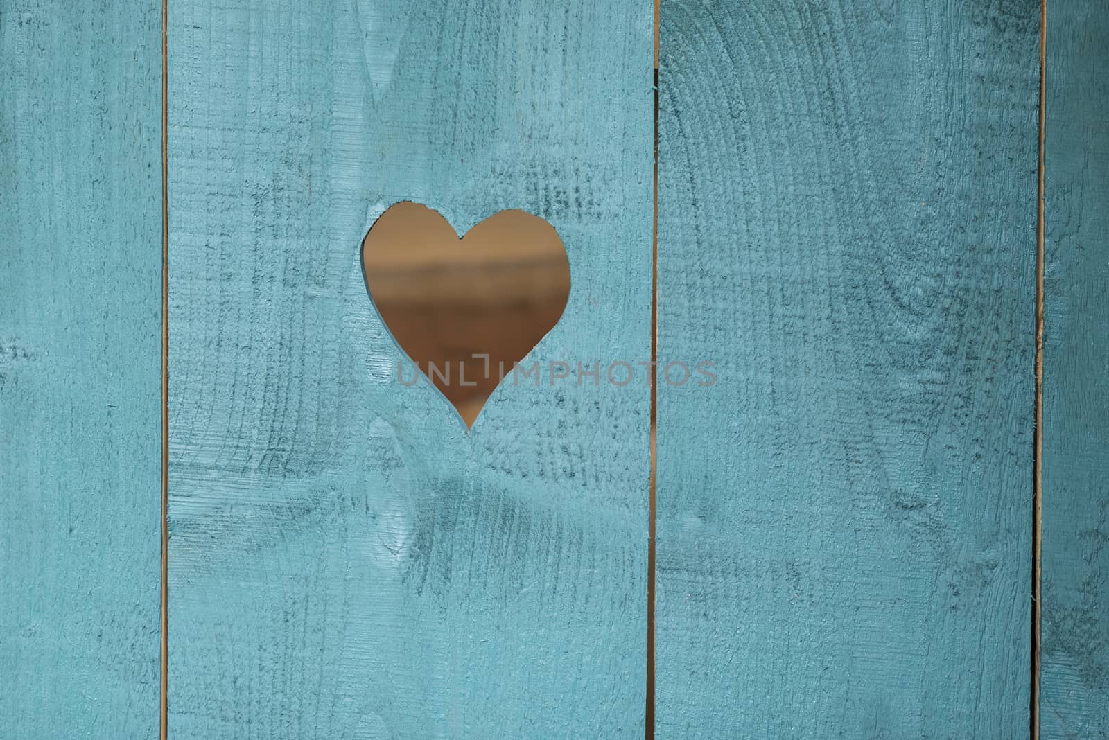 Sawn out heart in a blue background of rough wooden shelves
