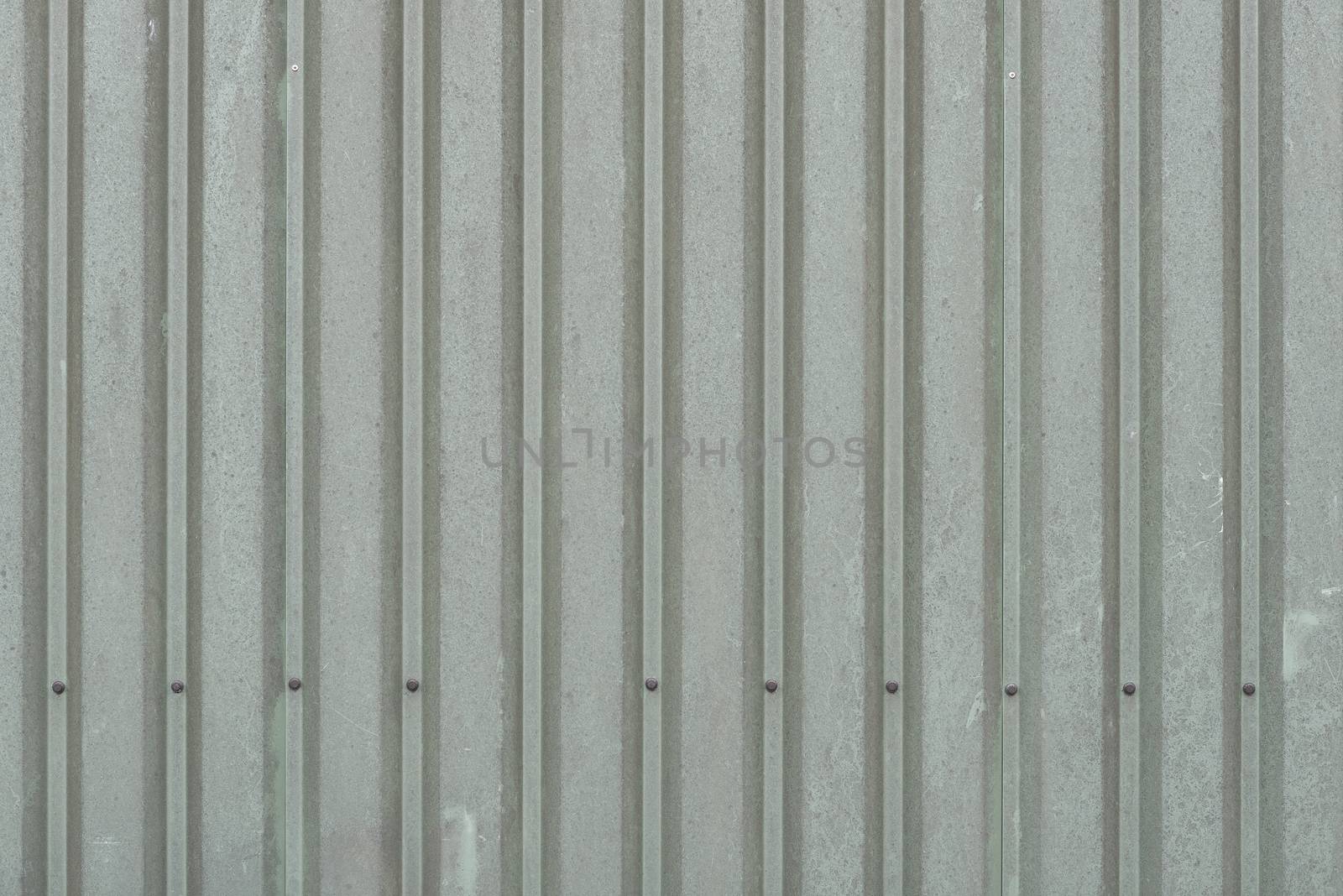 Background of weathered dark green metal wall panels on a barn
