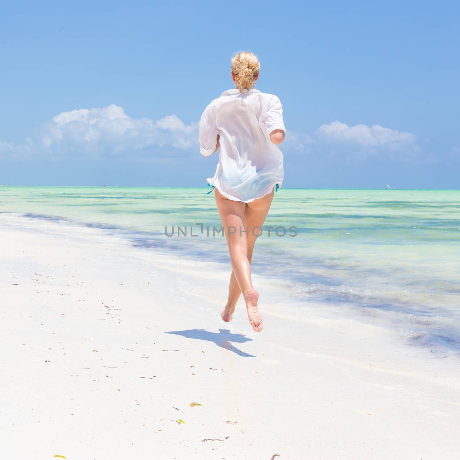 Happy woman having fun, enjoying summer, running joyfully on tropical beach. by kasto