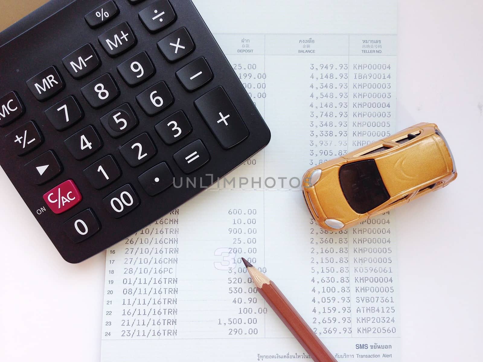 Business, finance, saving money, banking or car loan concept : Miniature car model, calculator, and saving account book or financial statement on office desk table