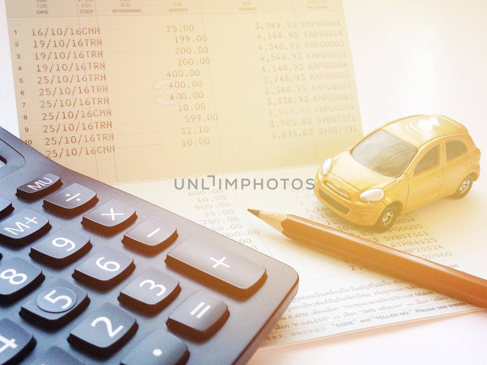 Business, finance, saving money, banking or car loan concept : Miniature car model, calculator and saving account book or financial statement on office desk table