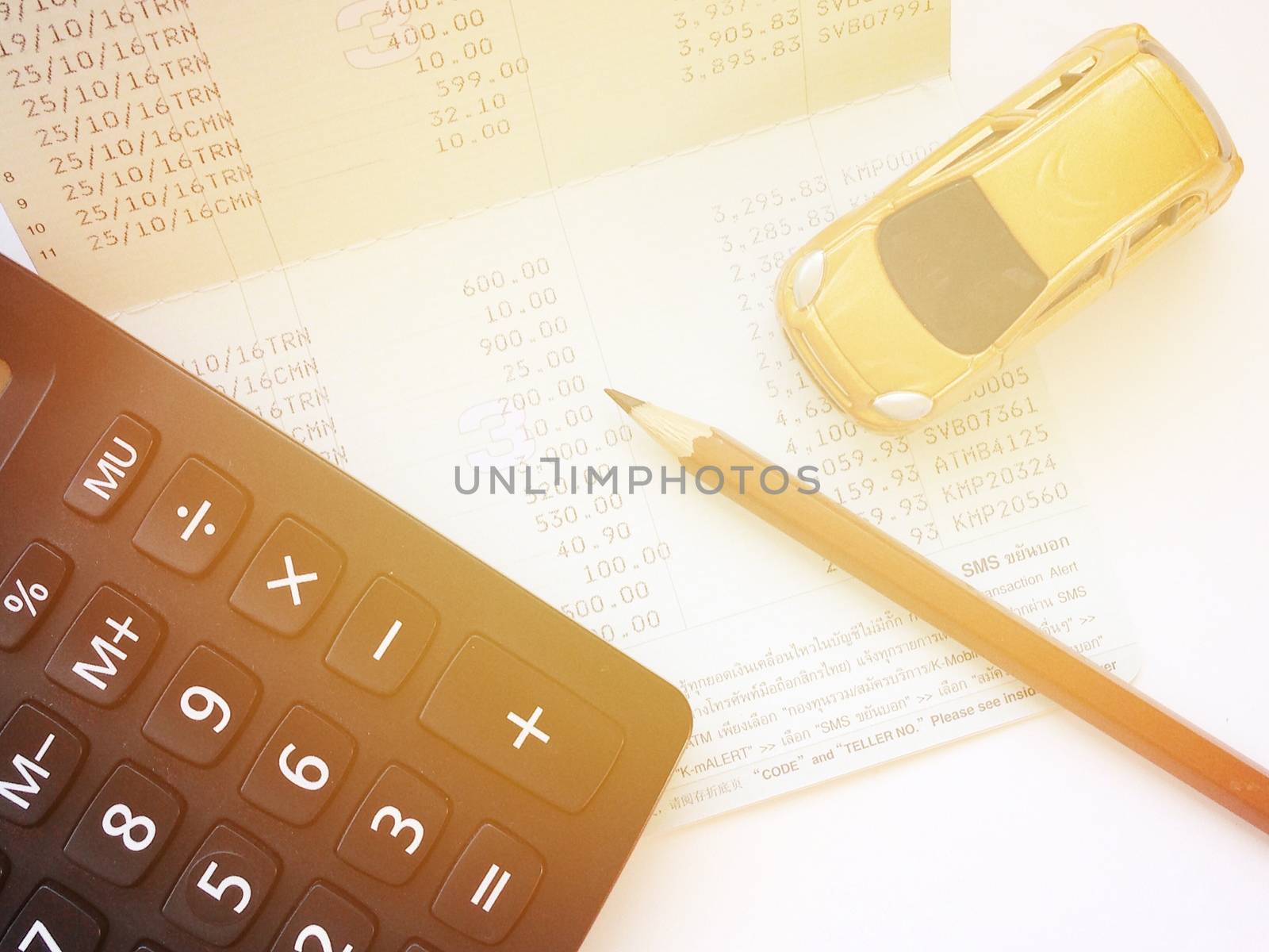 Business, finance, saving money, banking or car loan concept : Miniature car model, calculator and saving account book or financial statement on office desk table