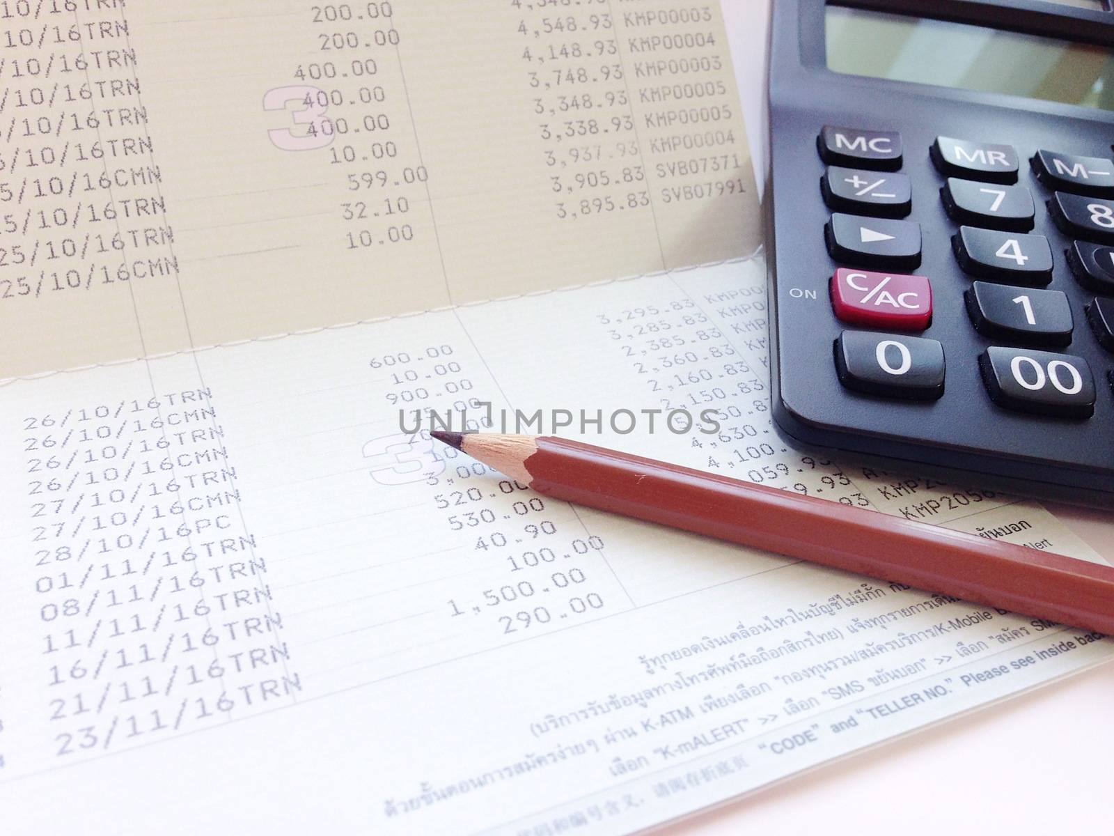 Business, finance, investment or accounting concept : Calculator and saving account book or financial statement on office table