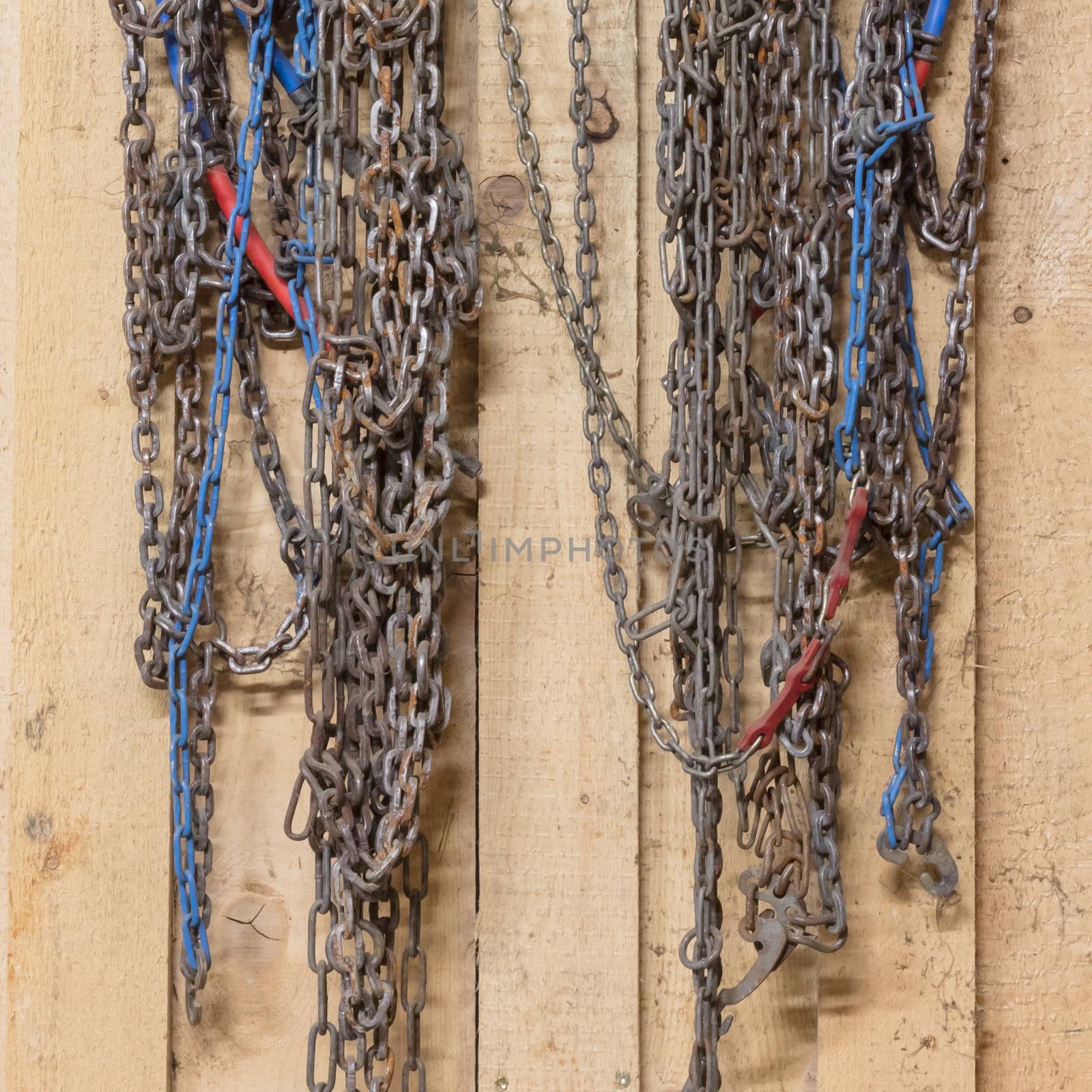 Old snow chains hanging in a barn by michaklootwijk