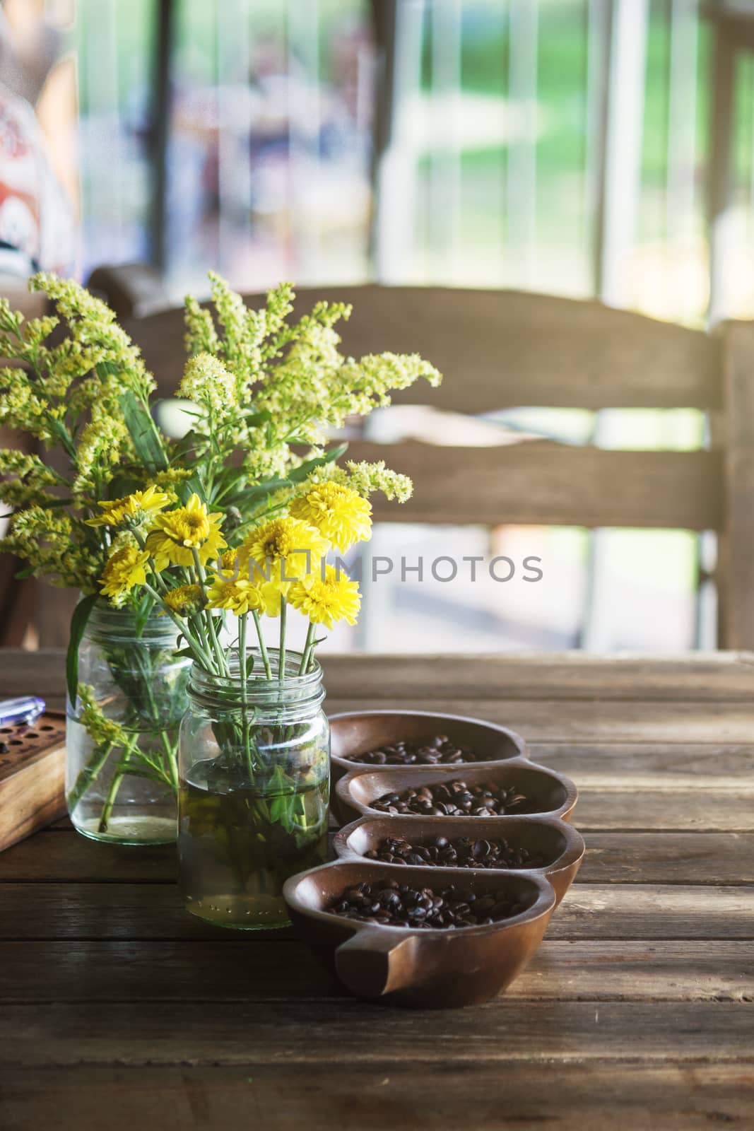 yellow flowers in wood potted on bokeh for background by rakoptonLPN