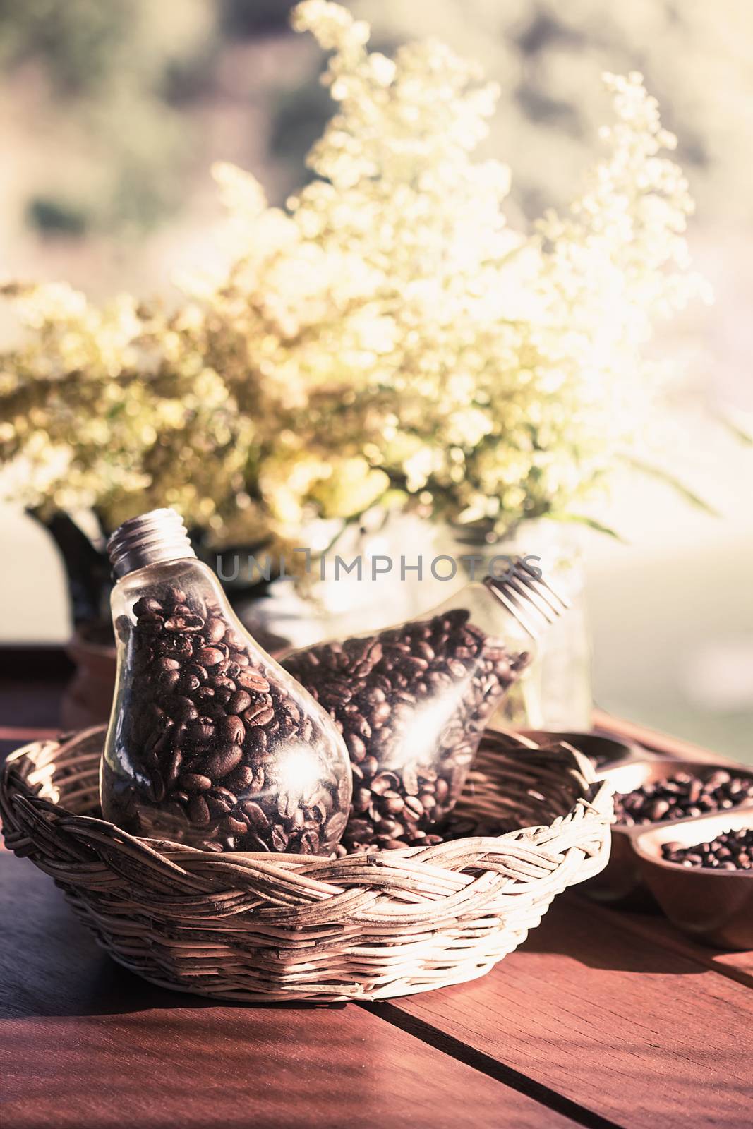 coffee bean in glass bottle on soft light bokeh of flower for background
