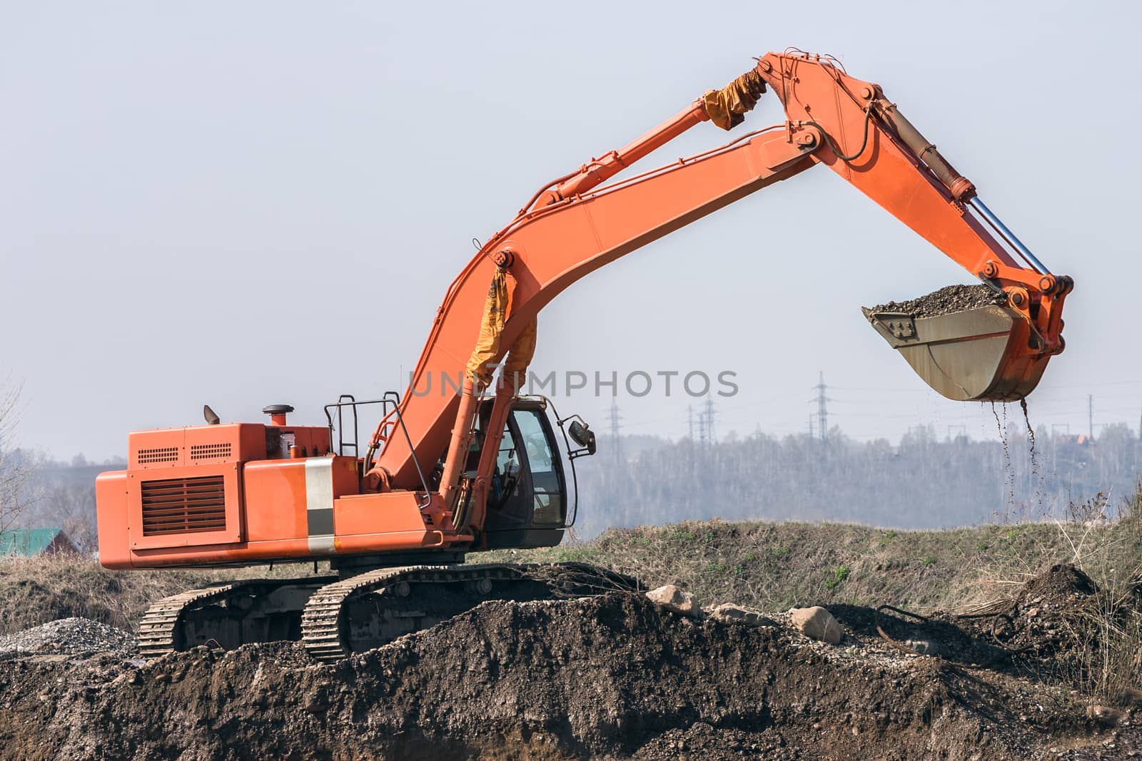 red excavator digs the ground