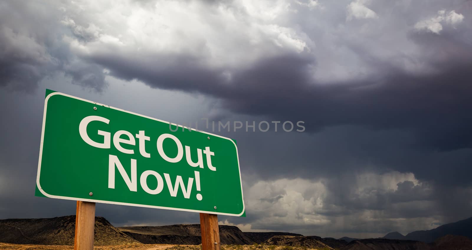 Get Out Green Road Sign with Dramatic Clouds and Rain.