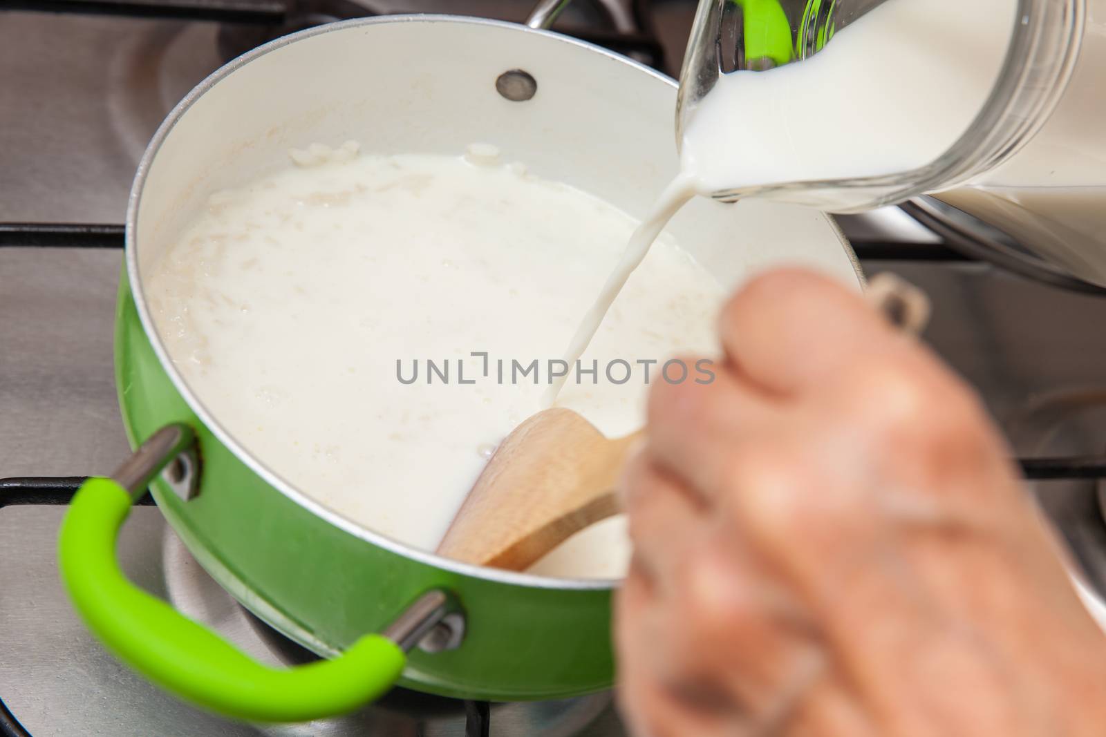 Rice Pudding with cinnamon and raisins preparation : Adding milk to the cooked rice