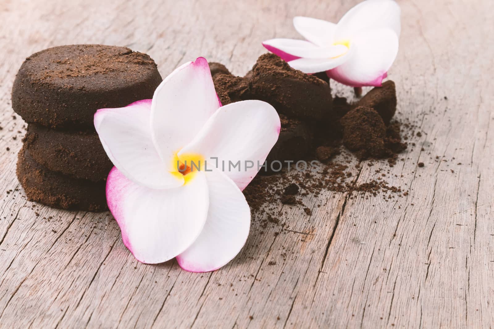 Closeup Plumeria sweet color and coffee ground on old wood background, skin care beauty and spa relax concept