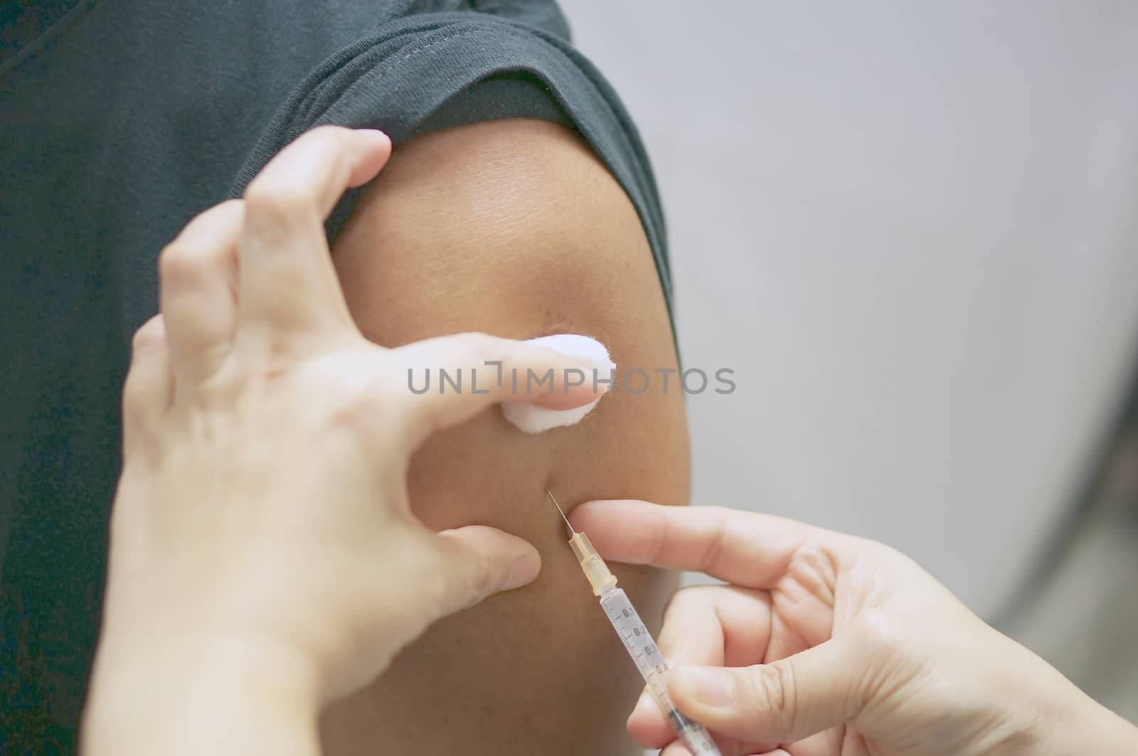 Nurse holding hypodermic syringe is injecting vaccine with patient man by eaglesky