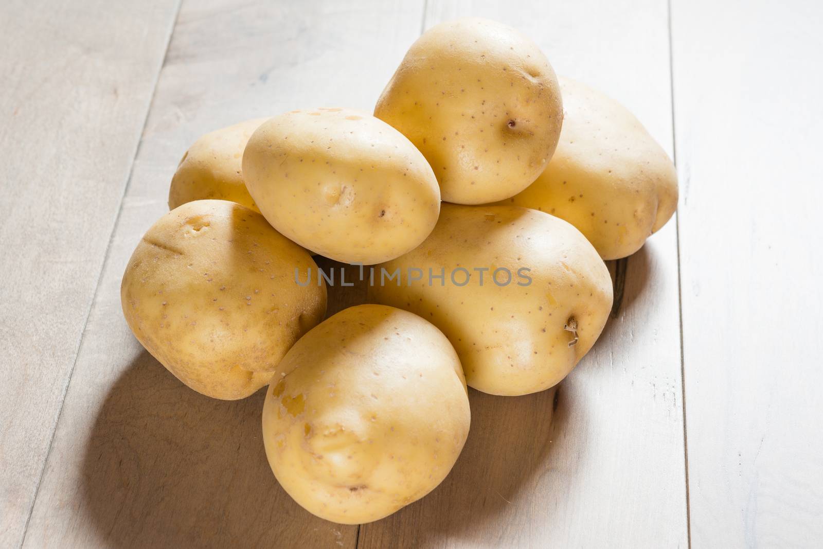 Yukon white potatoes photographed on a wooden table