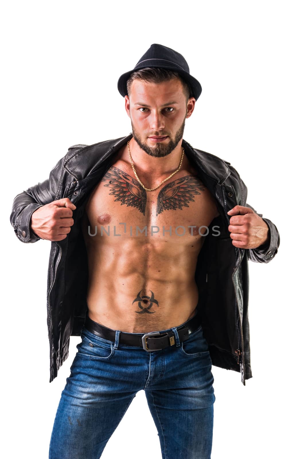 Muscular man with leather jacket on naked torso, wearing fedora hat, isolated on white background in studio